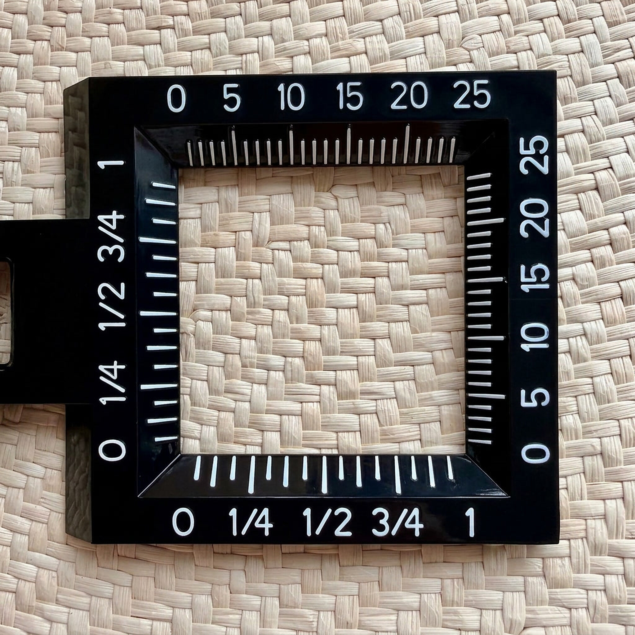 Medidor de grados sobre el tejido de paja toquilla: una plantilla con escala numerada permite contar las hebras por pulgada que determinan la finura del sombrero.